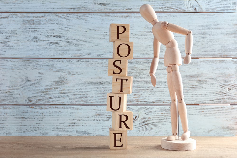 artists' mannequin next to lettered wooden blocks stacked to spell the word posture